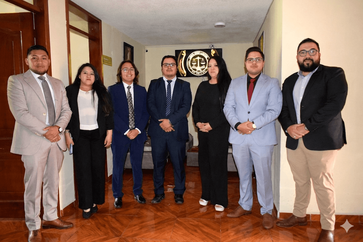 Siete profesionales en trajes formales posan en una oficina frente a un logotipo legal.